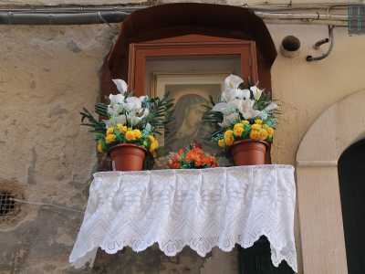Sempre in via Tancredi, il quadro di un'altra vergine abbellito da fiori 
